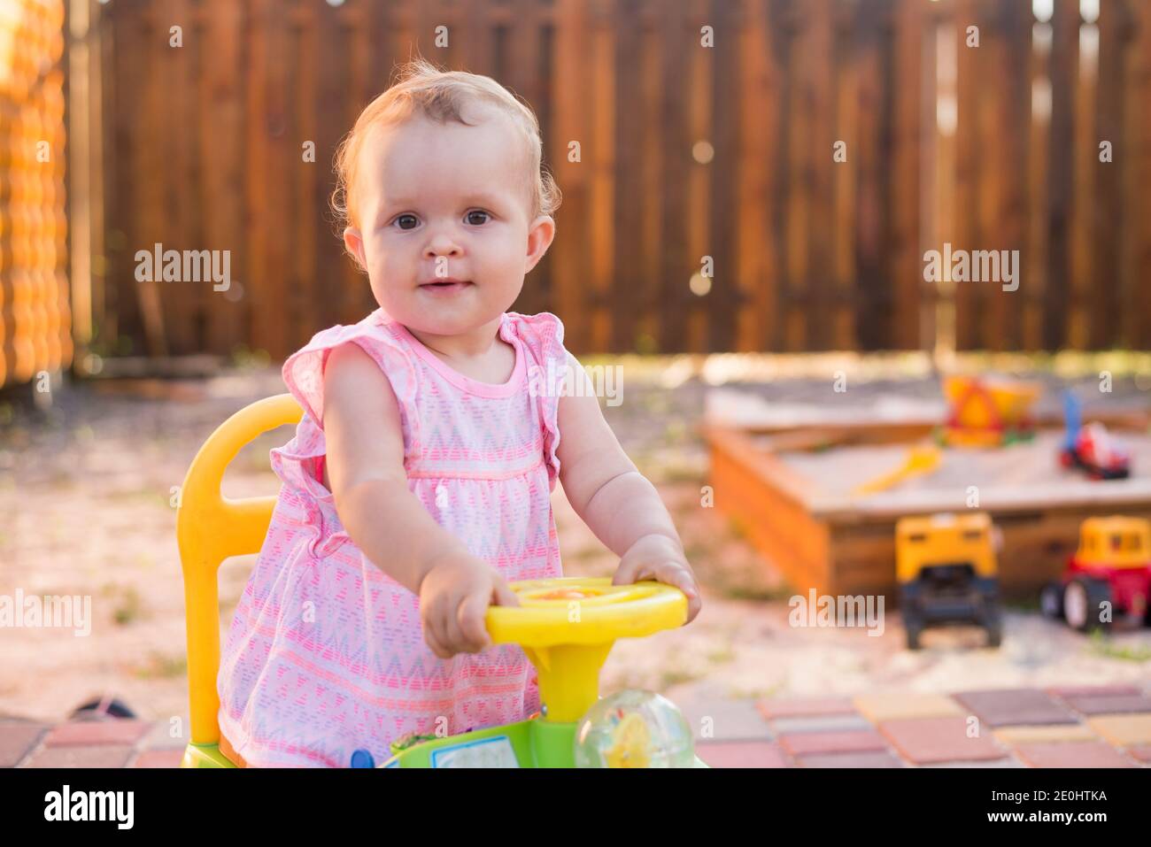 Baby girl driving a toy car at the playground outdoor Stock Photo Alamy