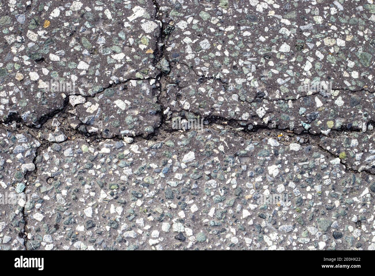 gray asphalt with a crack, interspersed with fine gravel. Road surface texture. Background for text Stock Photo