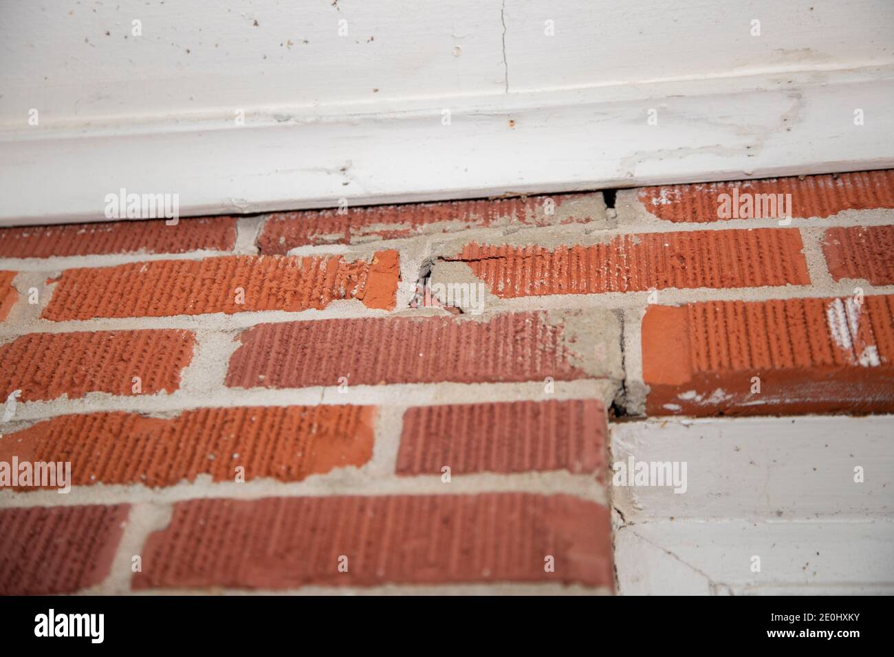 Cracked seals between the bricks above a door Stock Photo
