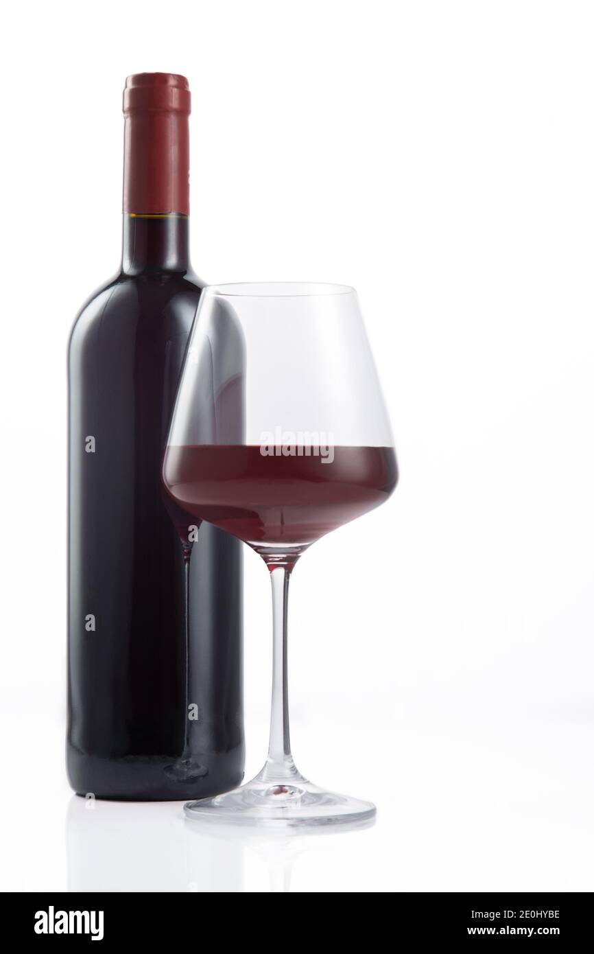 Bottle of red wine poured into the wine glass, on white background. Stock Photo