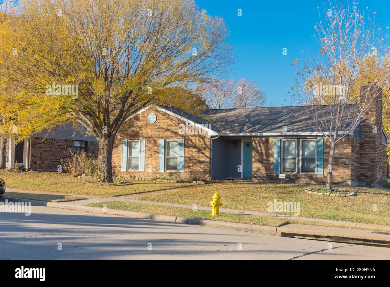 Typical suburban corner house with colorful fall foliage in suburbs