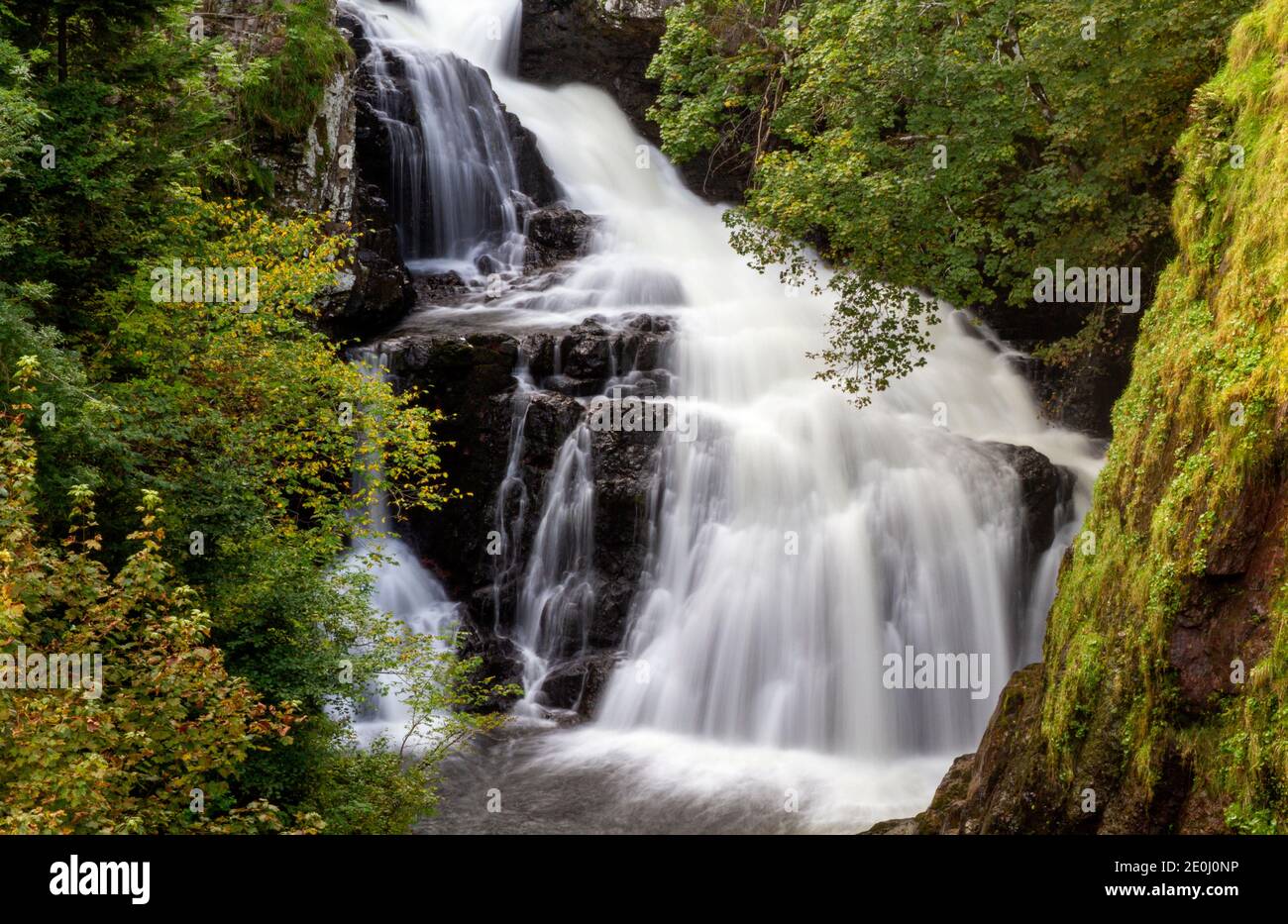 Autumn view of the misty Linn Falls at the famous Angus Glens of Glen Isla. Reekie Linn is of Scotland’s most spectacular waterfalls that cascades through a deep tree-lined canyon with beautiful autumnal and colourful scenery west of the Angus County in Scotland, UK Stock Photo