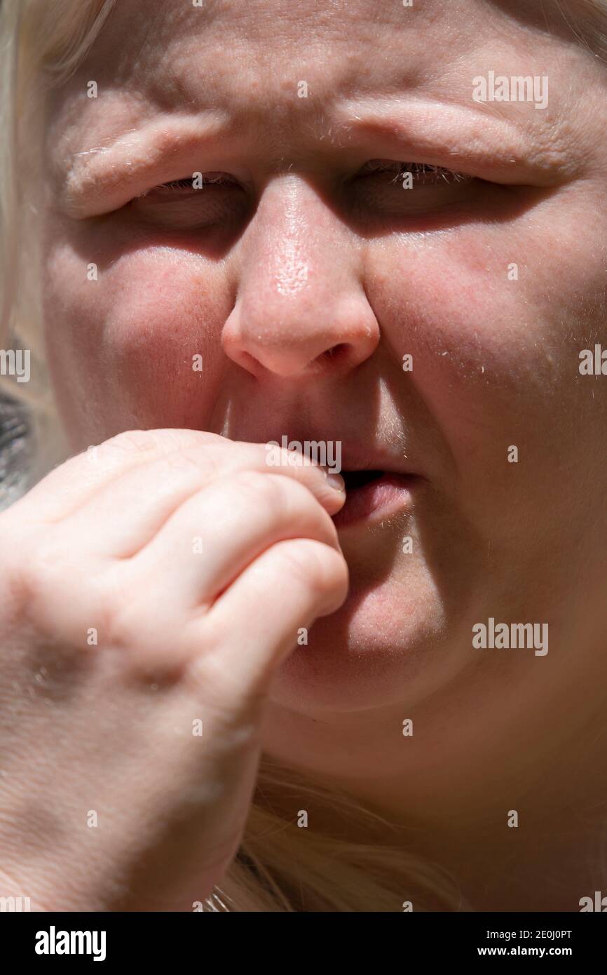 Close up of a woman eating a single french fry Stock Photo