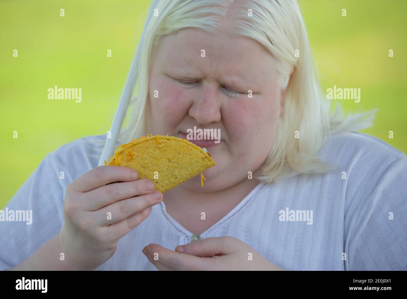 Close up of an albino woman eating taco outdoors Stock Photo