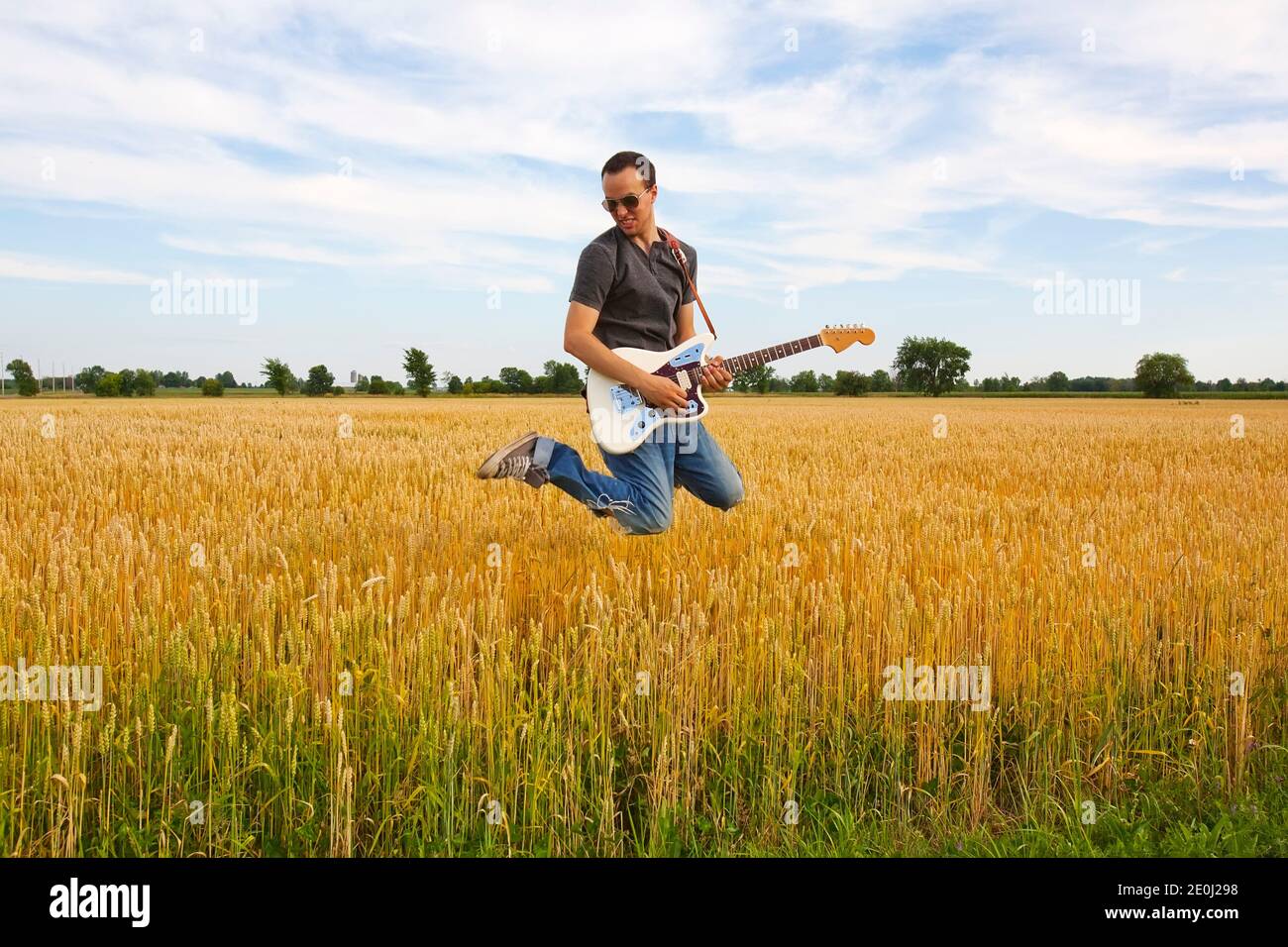 Guy Playing Electric Guitar In Wheat Field Stock Photo