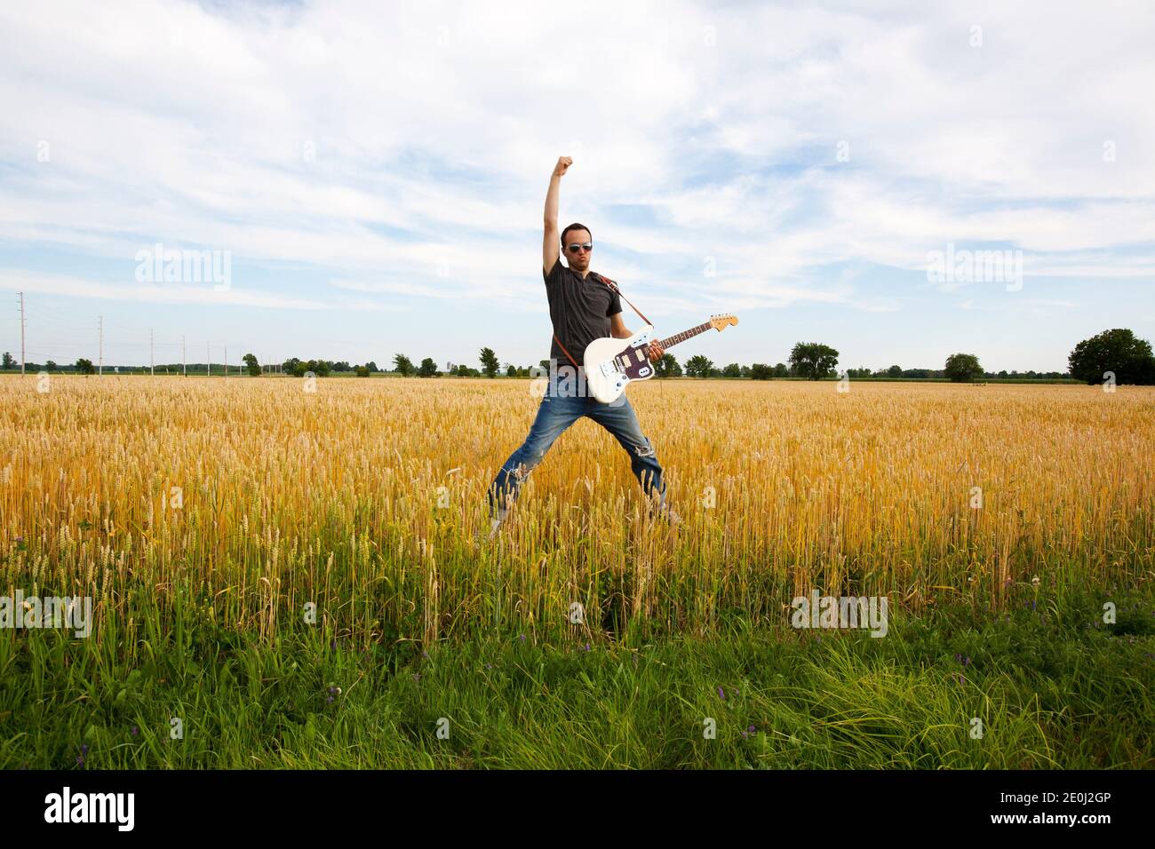 Guy Playing Electric Guitar In Wheat Field Stock Photo