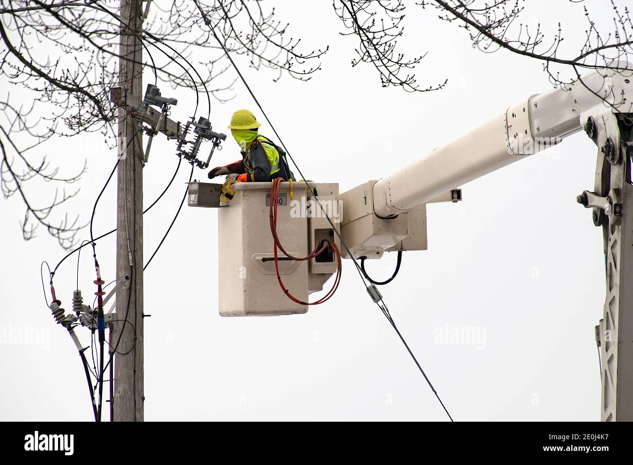 electrician in lift bucket repairing power transformer on a wooden pole  outdoors Stock Photo - Alamy