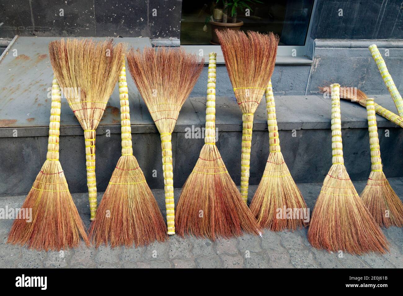 Sale of straw brooms on the Yerevan street Stock Photo