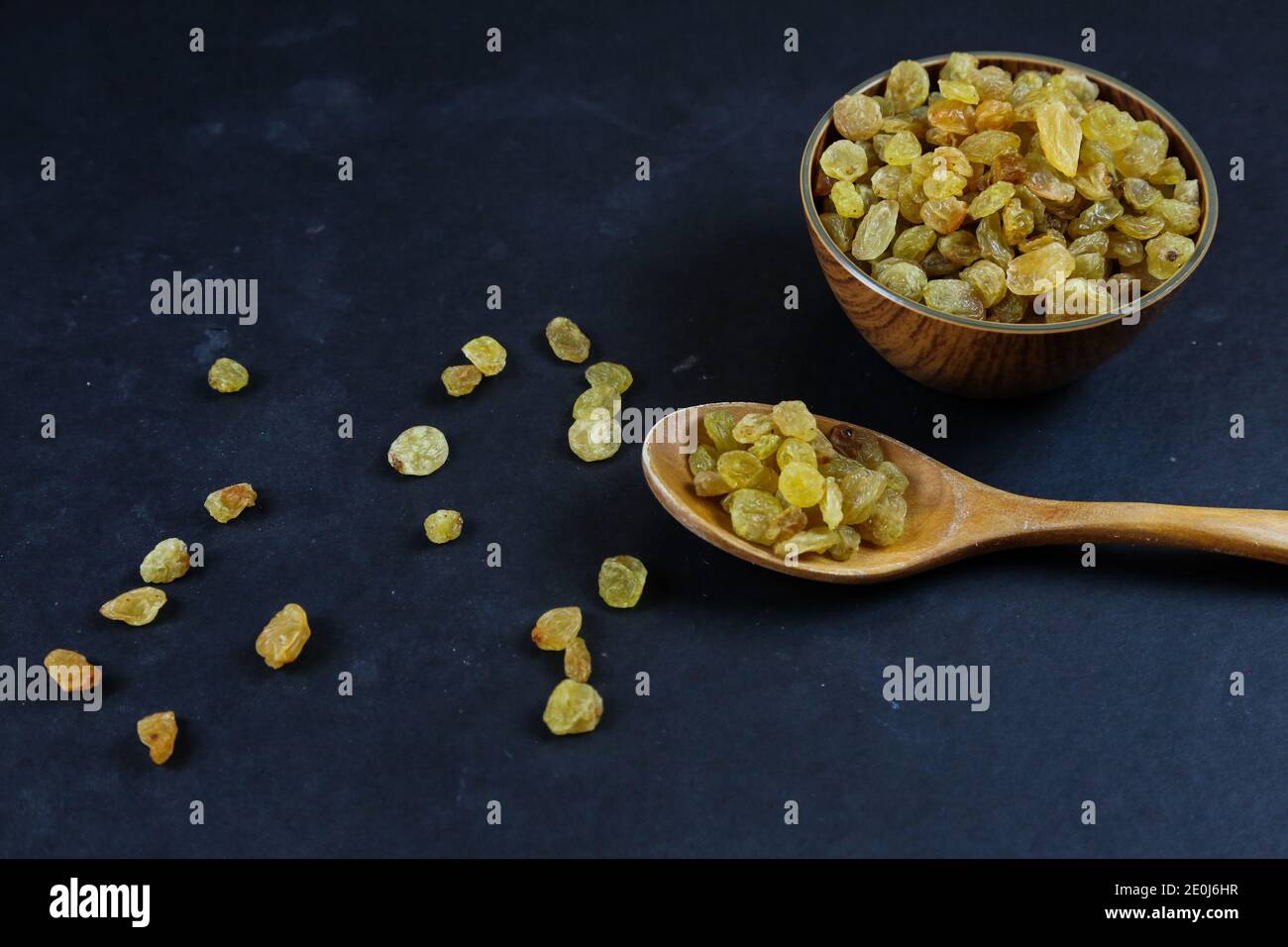 Dried raisins on black background Stock Photo - Alamy