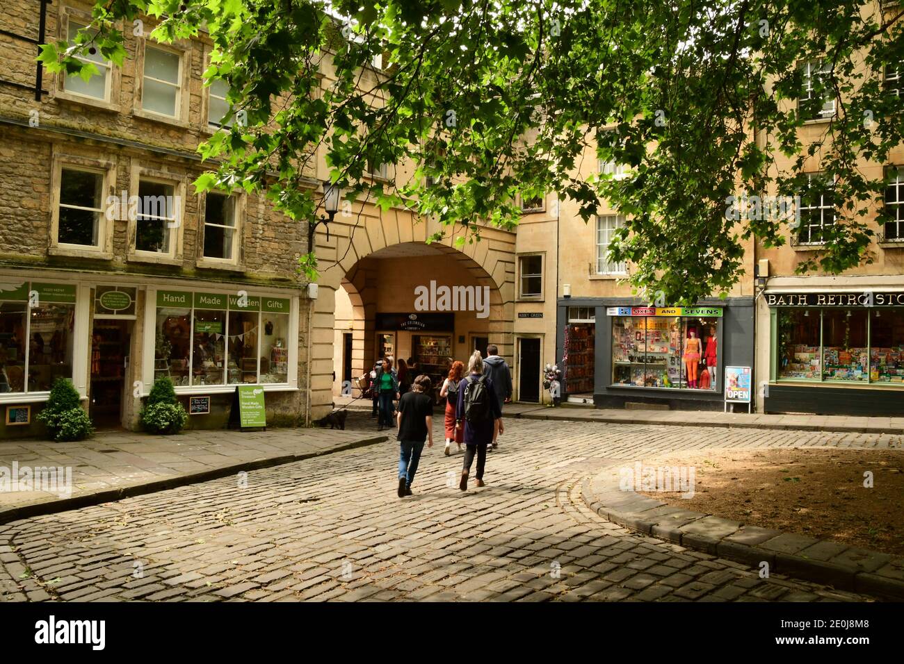 Tourists enjoying the peace and tranquility as they walk through the Abbey Green in the centre of the historic city of Bath, Somerset Stock Photo