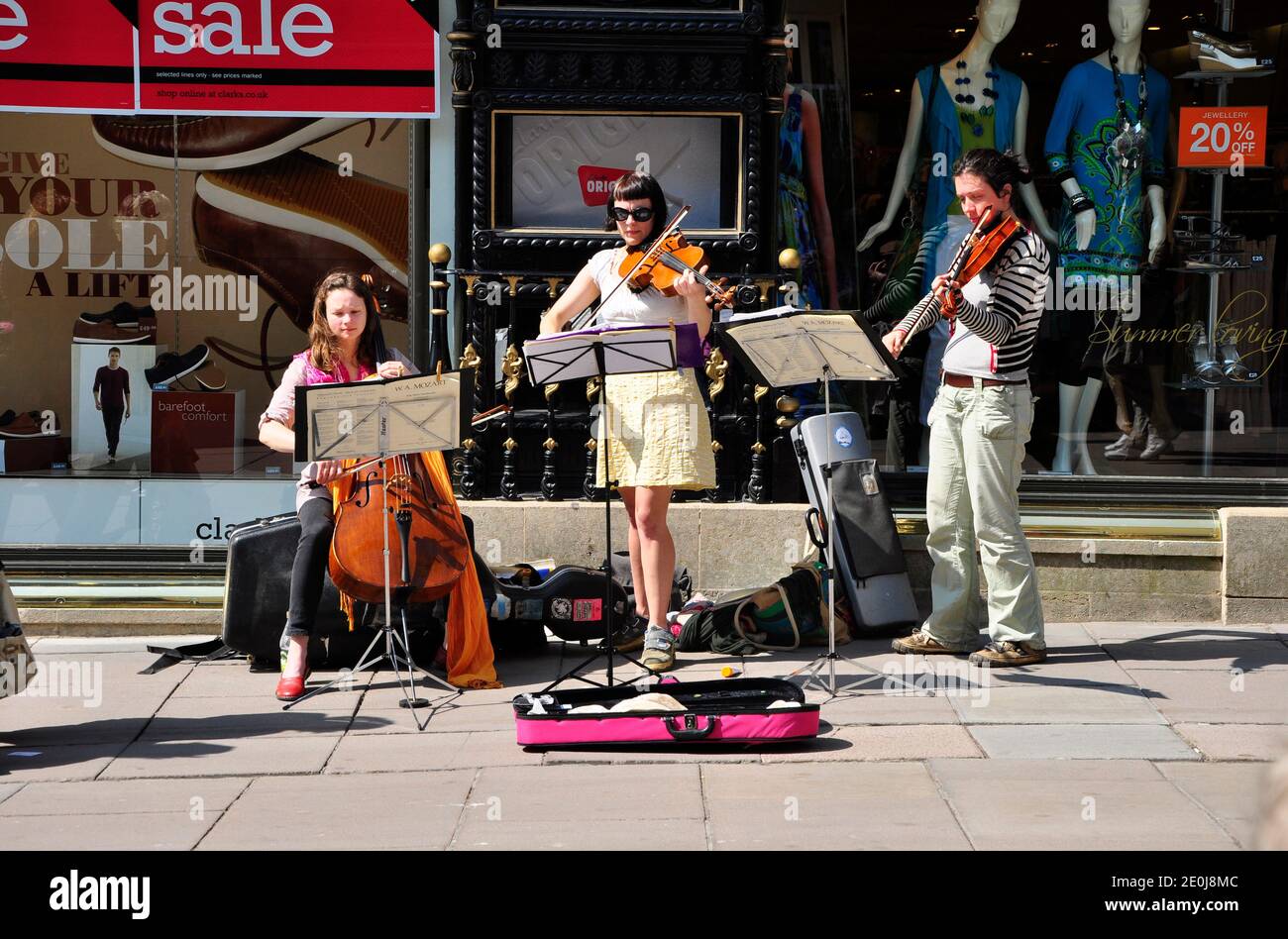 A classical music trio busking in the spring sunshine in the centre of