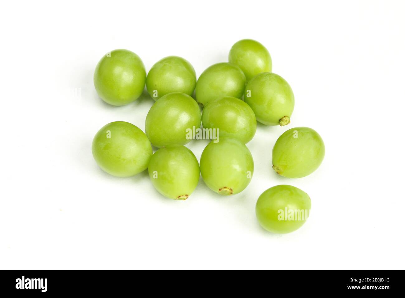 Pile of green unripe grape beans isolated on white background. Organic fruit Stock Photo
