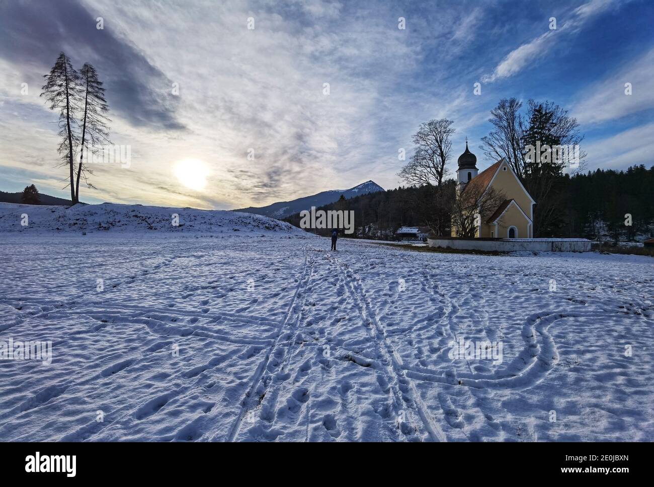 Kochel, Bavaria, Germany. 1st Jan, 2021. Sunset over a snowy trail frequented by hikers and cross country skiiers at Lake Walchen (Walchensee) in the Voralpenland (Pre Alps) of Bavaria, Germany. Credit: Sachelle Babbar/ZUMA Wire/Alamy Live News Stock Photo