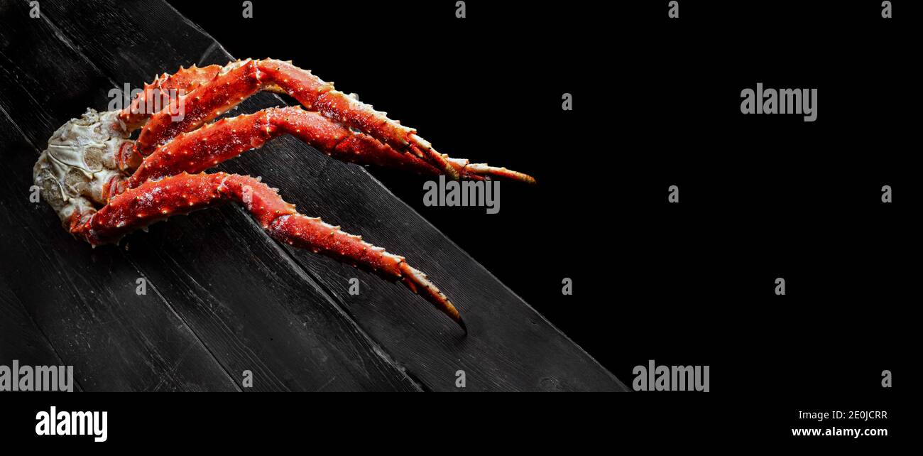 Fresh red king crab crab claws on vintage wooden background. Tasty kamchatka crab's claw. Top View with Copy space.  Stock Photo