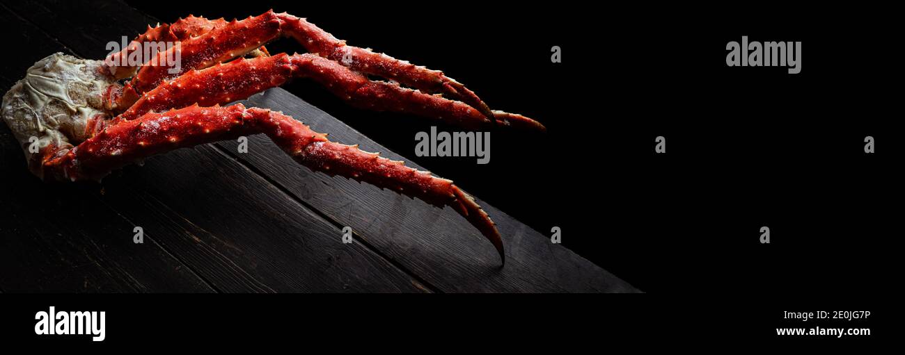 Fresh red king crab crab claws on vintage wooden background. Tasty kamchatka crab's claw. Top View with Copy space.  Stock Photo