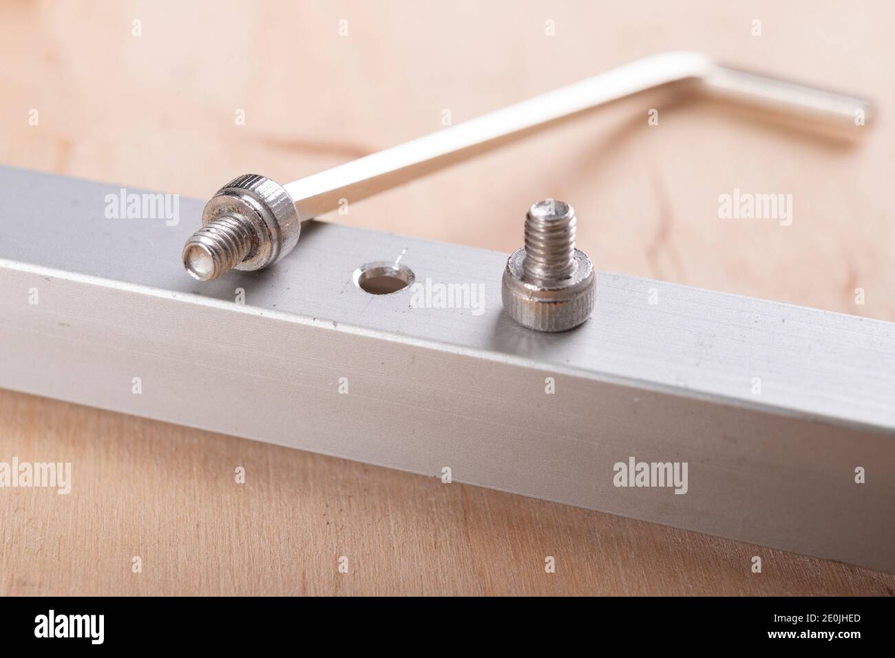 Tighten the small screws with an Allen key. Locksmith works in the workshop. Light background. Stock Photo