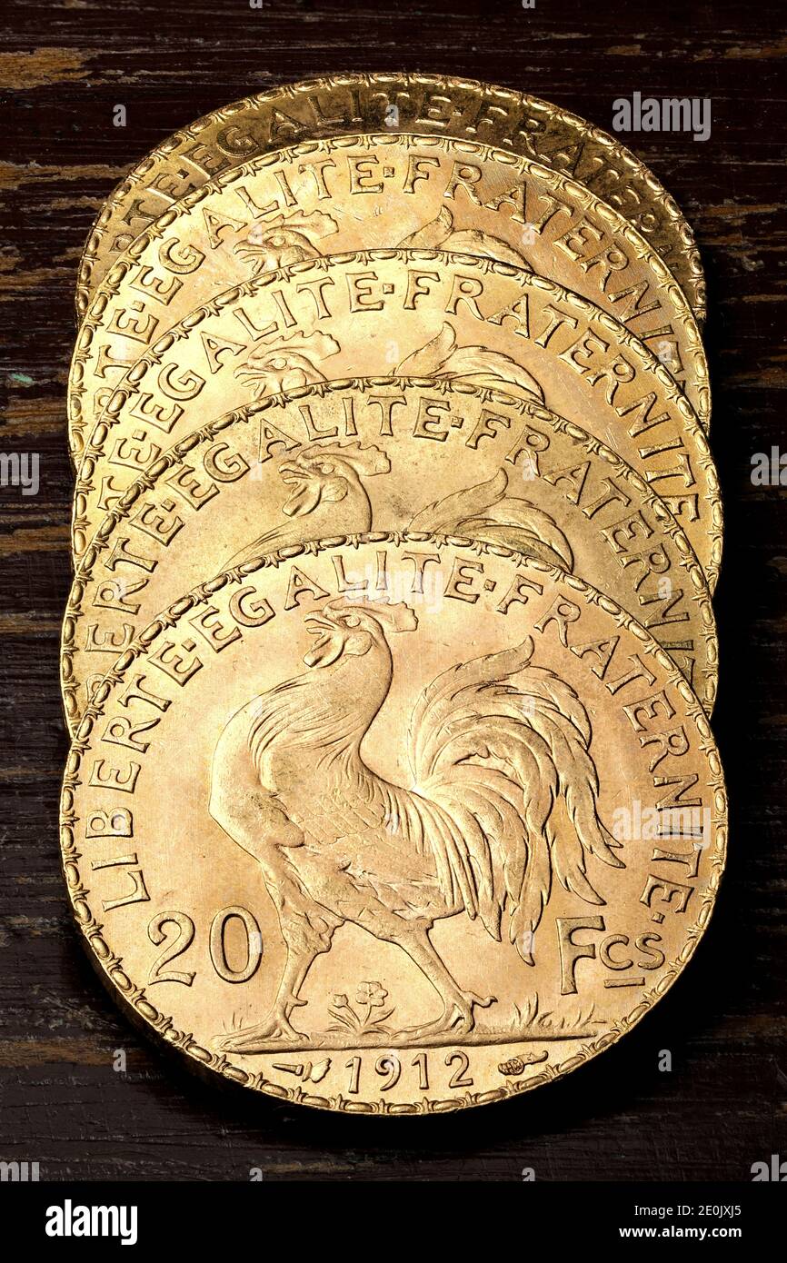 French 20 Francs gold coins (reverse with rooster) on rustic wooden background Stock Photo
