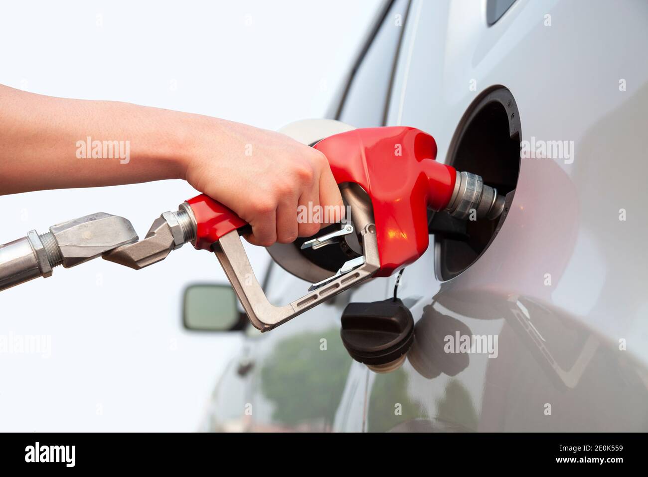 Isolated arm and hand of a young man pumping gas into his car Stock Photo