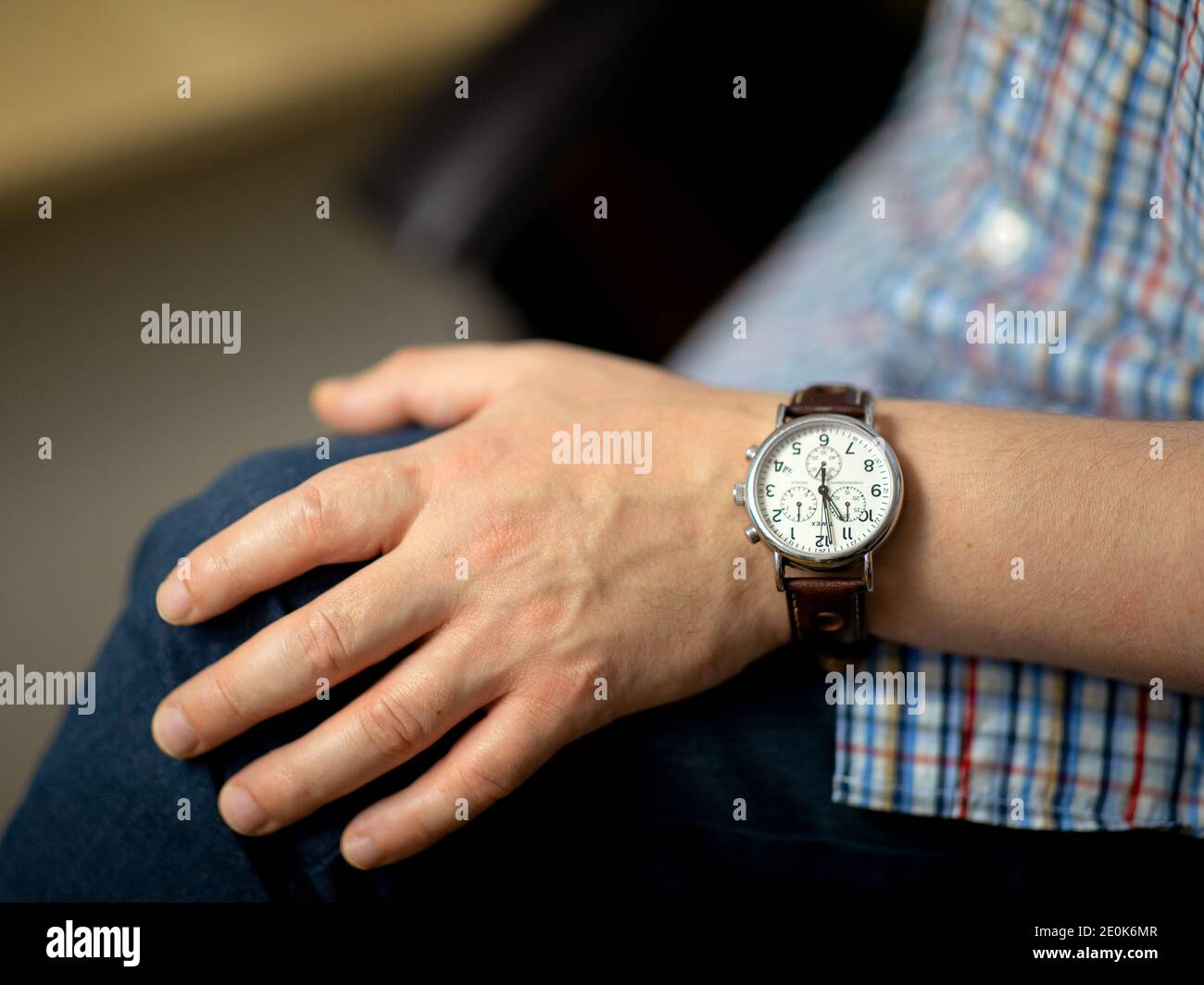 Classic men's timex watch with leather strap matched to the left hand with  eleven o'clock Stock Photo - Alamy