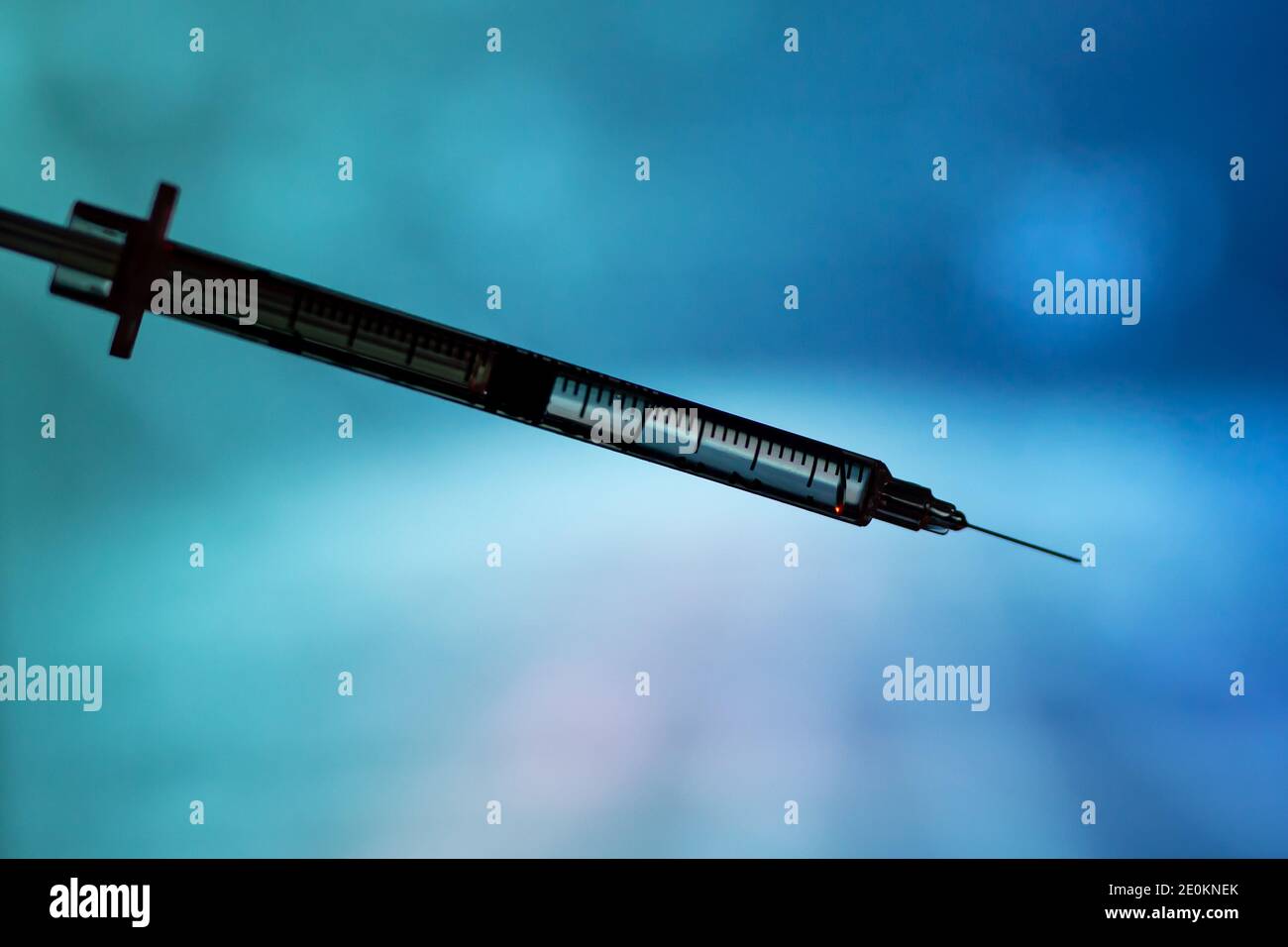 Medical syringe for a vaccine. Blue background Stock Photo - Alamy