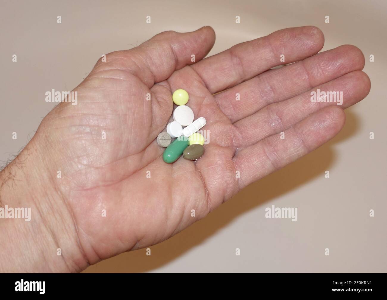 geöffnete Hand mit mehreren Tabletten - Symbolbild für Medikamentenabhängigkeit Stock Photo
