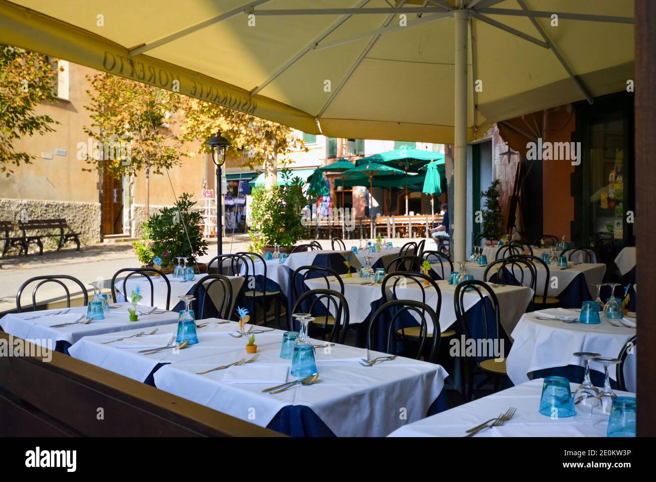 Sidewalk cafe restaurant in Monterosso Al Mare on the ligurian coast of Cinque Terre Italy on a summer afternoon with tables set Stock Photo
