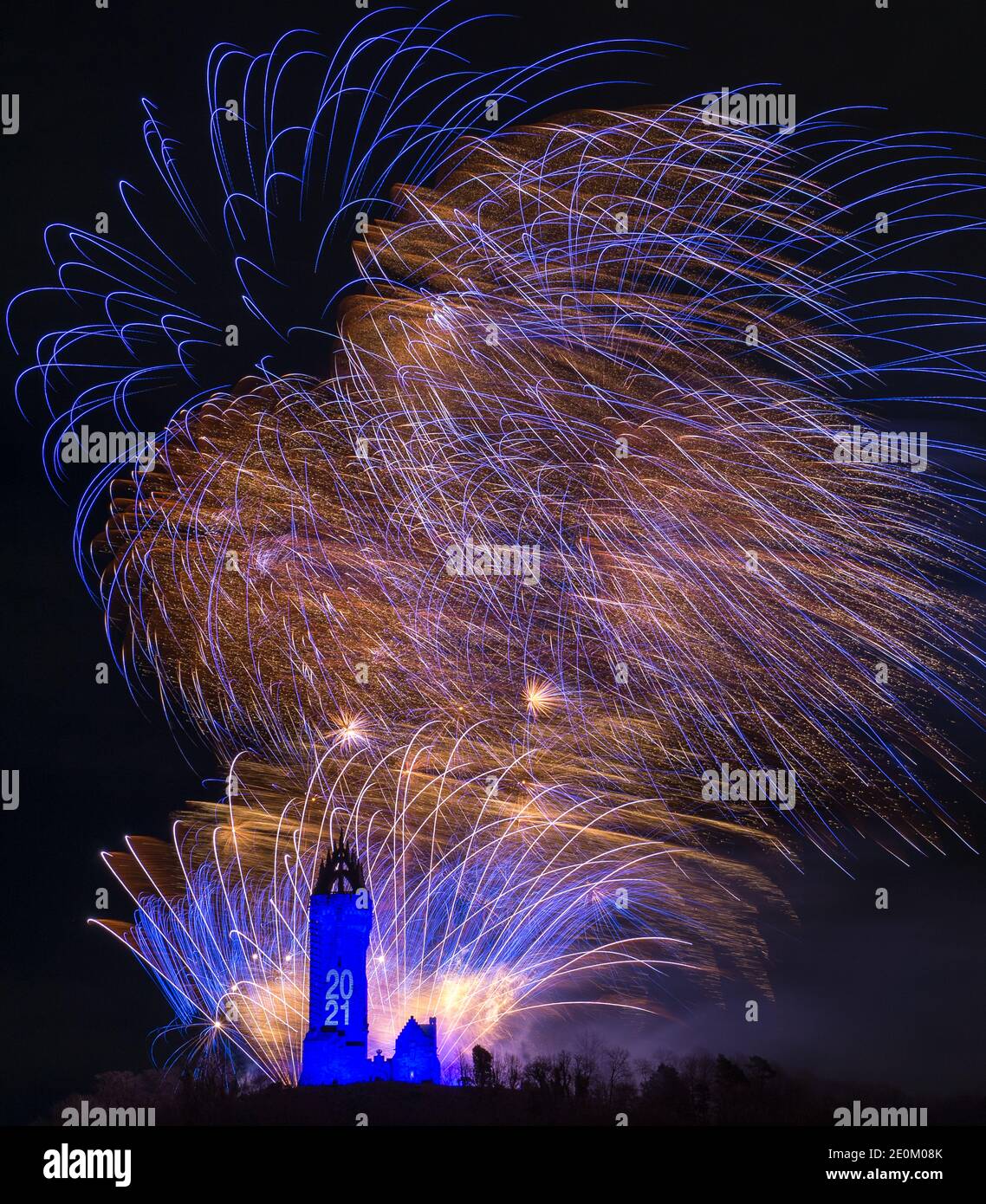 Stirling, Scotland, UK. 1 January 2021. Pictured: Hogmanay pyrotechnic spectacular closes off 2020 and brings in 2021 with a bang as colourful explosions burst lighting up the new year night sky 600feet above the Wallace Monument in Stirling. Due to the coronavirus (COVID19) pandemic the show will be live streamed on TV and online since Scotland is in phase 4 lockdown. Edinburgh based events company, 21CC Events Ltd, pyrotechnic specialists have spent the last few days setting up the show including powerful projection lights for the monuments facade. Credit: Colin Fisher/Alamy Live News. Stock Photo