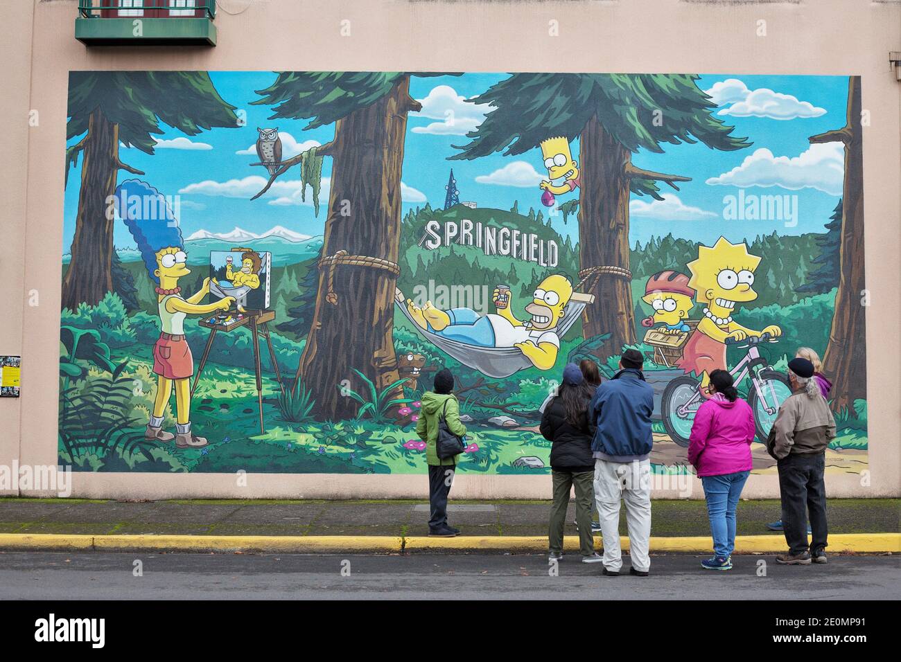 A group of people looking at a mural of the Simpsons, by Julius Preite, in downtown Springfield, Oregon. Stock Photo