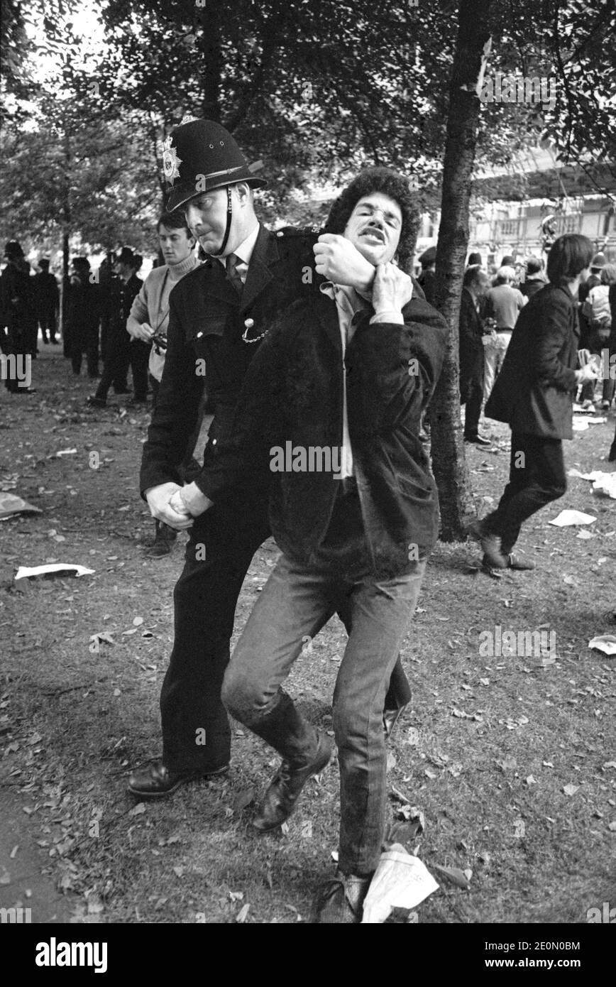 Policeman arresting protestor during anti-Vietnam War protest outside the US Embassy in Grosvenor Square, London, March 17, 1968. This protest became know as the Battle of Grosvenor Square and was inspiration for the Rolling Stone song, Street Fighting Man. Stock Photo