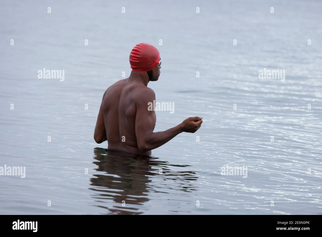 Seattle, Washington, USA. 1st January, 2021. Open-water swimmer Will Washington prepares to dive into Puget Sound at the annual West Seattle Polar Bear Swim at Alki Beach Park. Organizers arranged physically distanced sites and staggered timing along Alki Beach for participants amid a recent moderation of COVID-19 cases in the city. Credit: Paul Christian Gordon/Alamy Live News Stock Photo