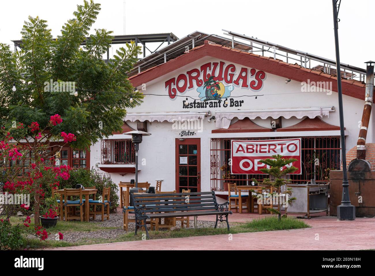 Tortuga’s Restaurant and Bar in San Carlos, Sonora, Mexico, with bars on windows, a pizza oven out front, and a bench in front for seating. Stock Photo