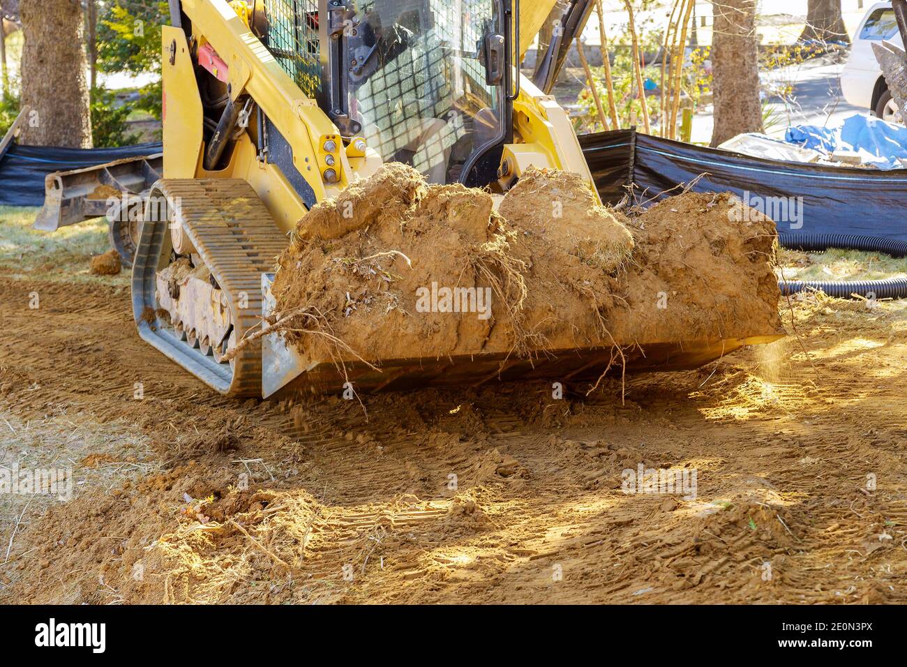 Mini bulldozer with earth doing landscaping works level the ground Stock Photo