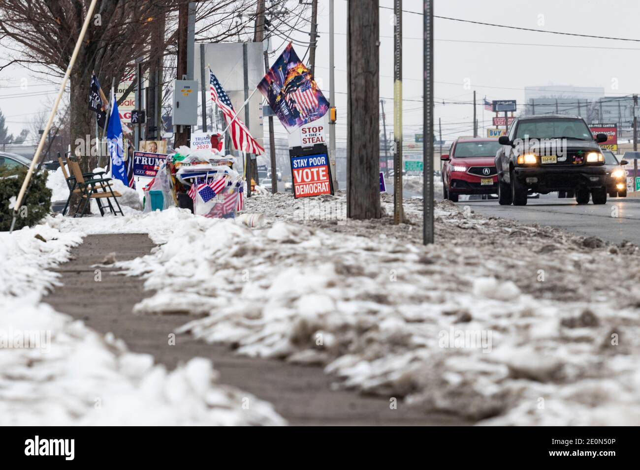 Various pro-Trump and anti-Biden signs and flags, set up roadside by Trump supporters in the snow several weeks after Trump loss in the 2020 election Stock Photo
