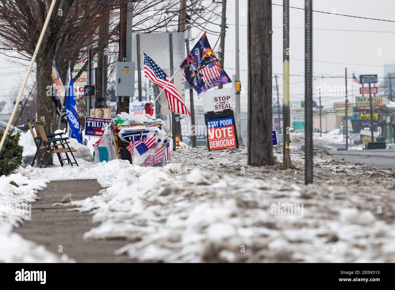 Various pro-Trump and anti-Biden signs and flags, set up roadside by Trump supporters in the snow several weeks after Trump loss in the 2020 election Stock Photo