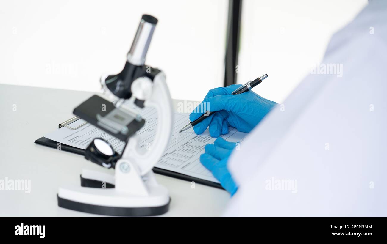 Young Asian scientist Working looking through a microscope doing ...