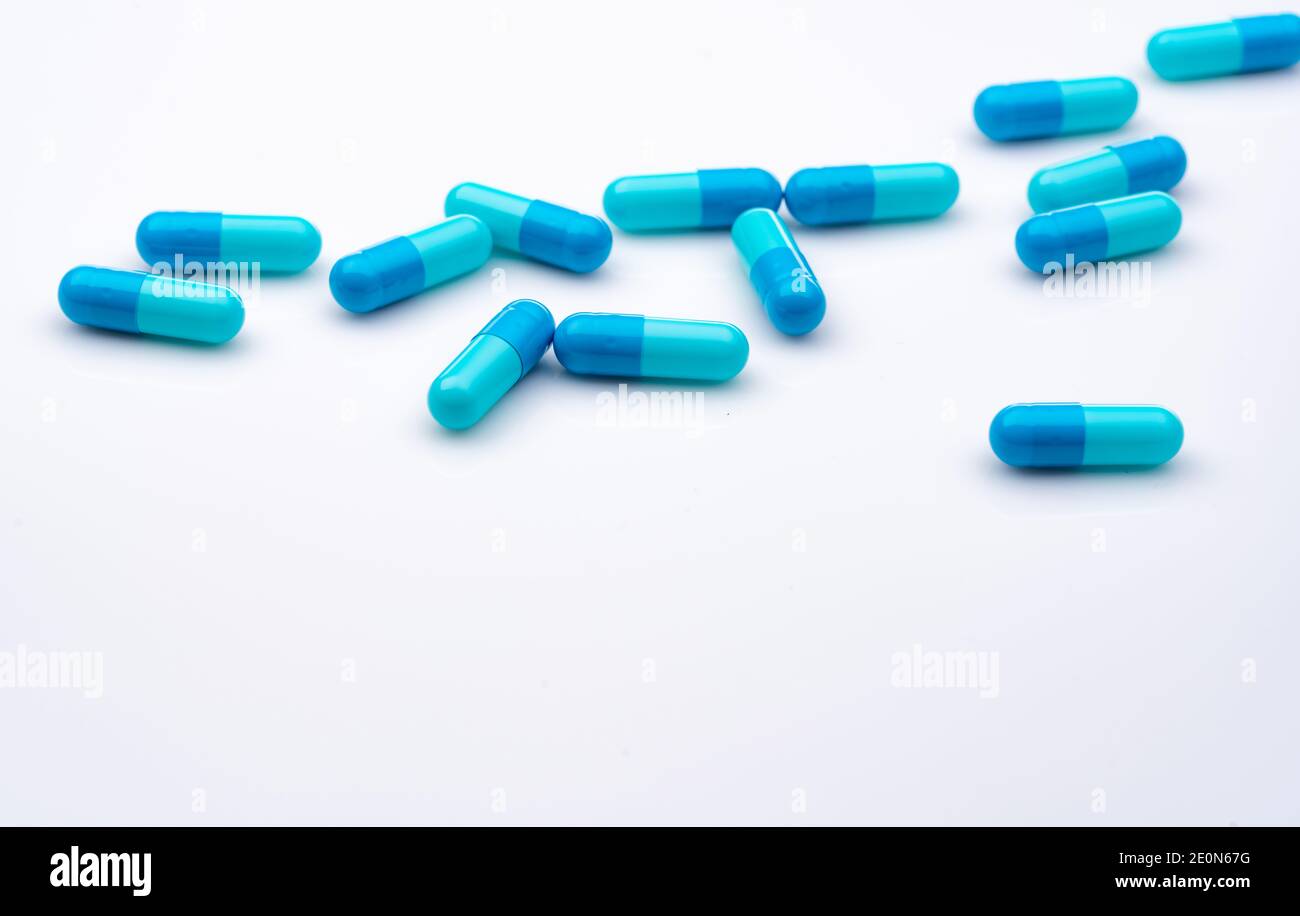 Blue capsule pills spread on white background. Pharmaceutical industry. Healthcare and medicine concept. Health budget. Prescription drug. Medication Stock Photo