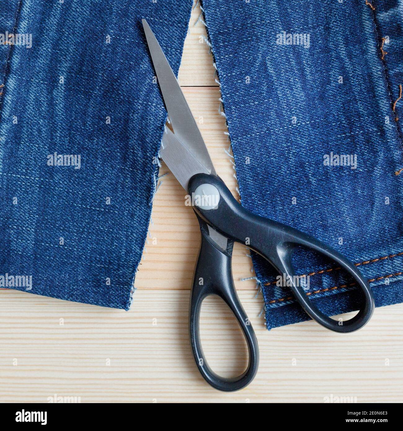 Scissors pieces of cut denim. Wood background Stock Photo Alamy