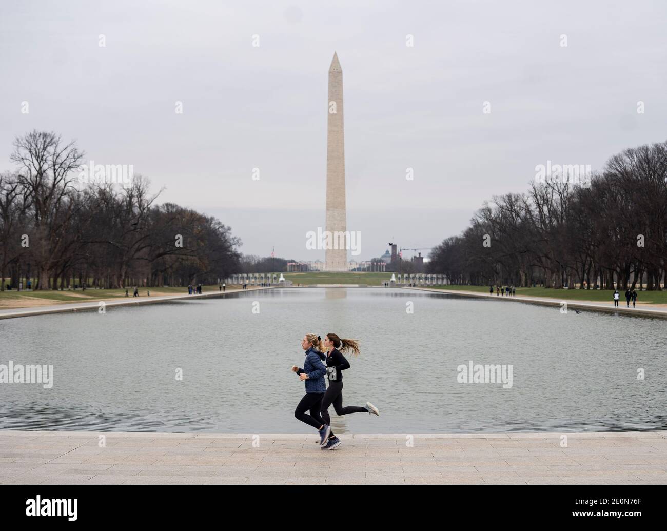 Washington, USA. 1st Jan, 2021. People jog near the Lincoln Memorial Reflecting Pool in Washington, DC, the United States, on Jan. 1, 2021. The confirmed COVID-19 cases in the United States topped 20 million on Friday as the discovery of a highly contagious new virus strain in the country increases pressure to speed up the vaccination process. Credit: Liu Jie/Xinhua/Alamy Live News Stock Photo