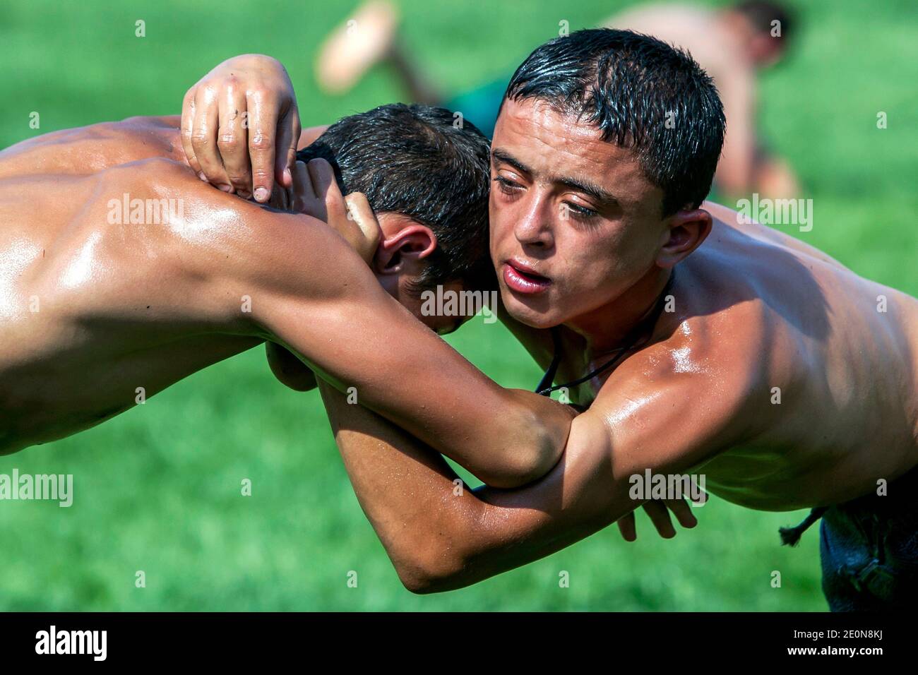 Young wrestlers with their arms locked, battle for victory at the Elmali Turkish Oil Wrestling Festival in Turkey. Stock Photo