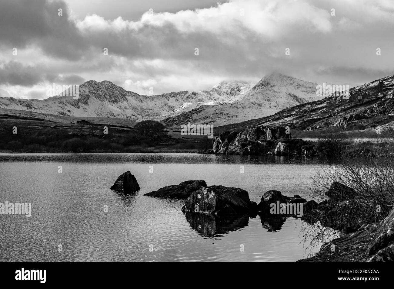 Looking down Llynnau Mymbyr lake towards Snowdon covered in snow. The lake is situated on the road to Capel Curig. Stock Photo