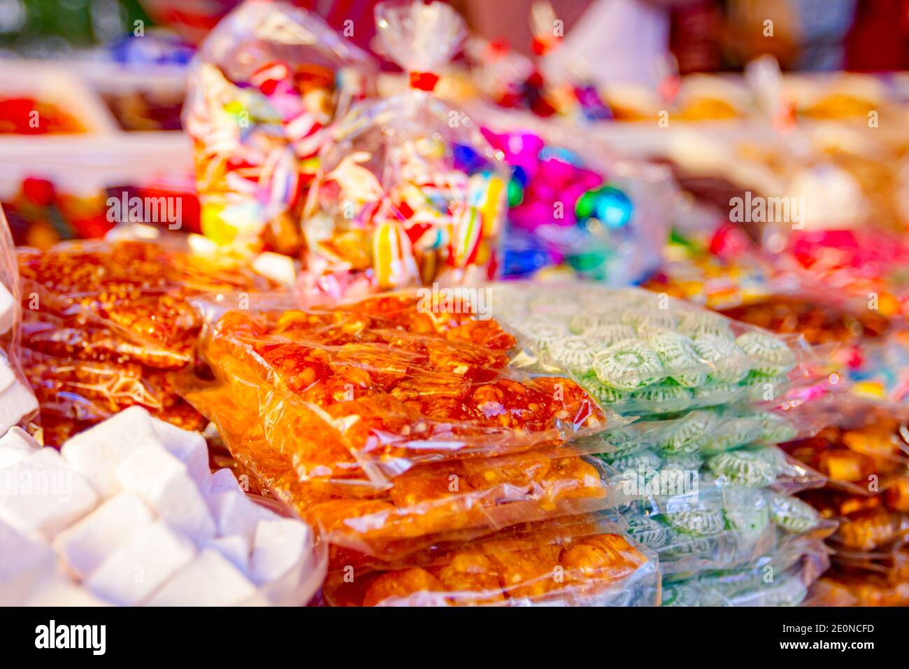 Various colored candies and sweets for sale placed in trays, available