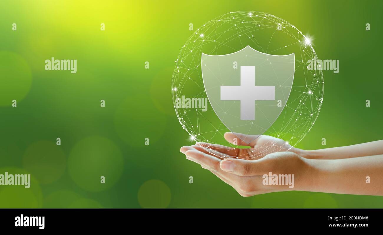 Hand offer medical shield on green background. Family life insurance, Medical care insurance, and Business healthy concepts. Stock Photo