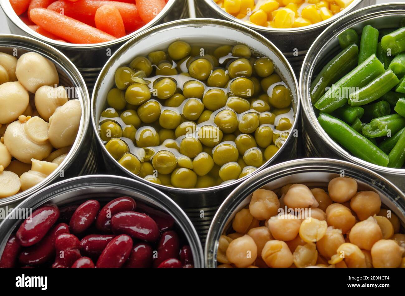 Canned vegetables in opened tin cans on kitchen table. Nonperishable