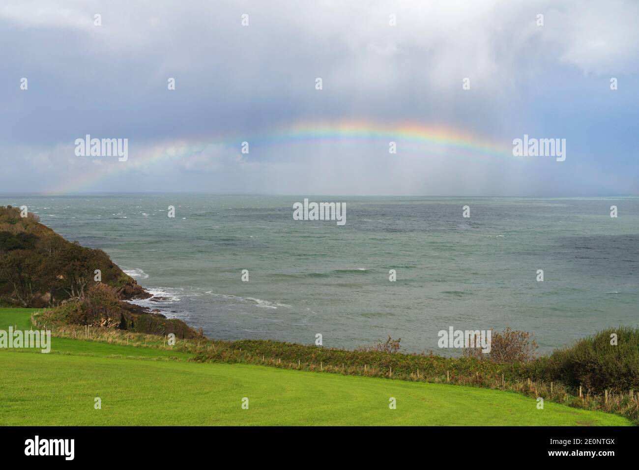 Rainbow out at sea off the Devon coastline - England, UK Stock Photo