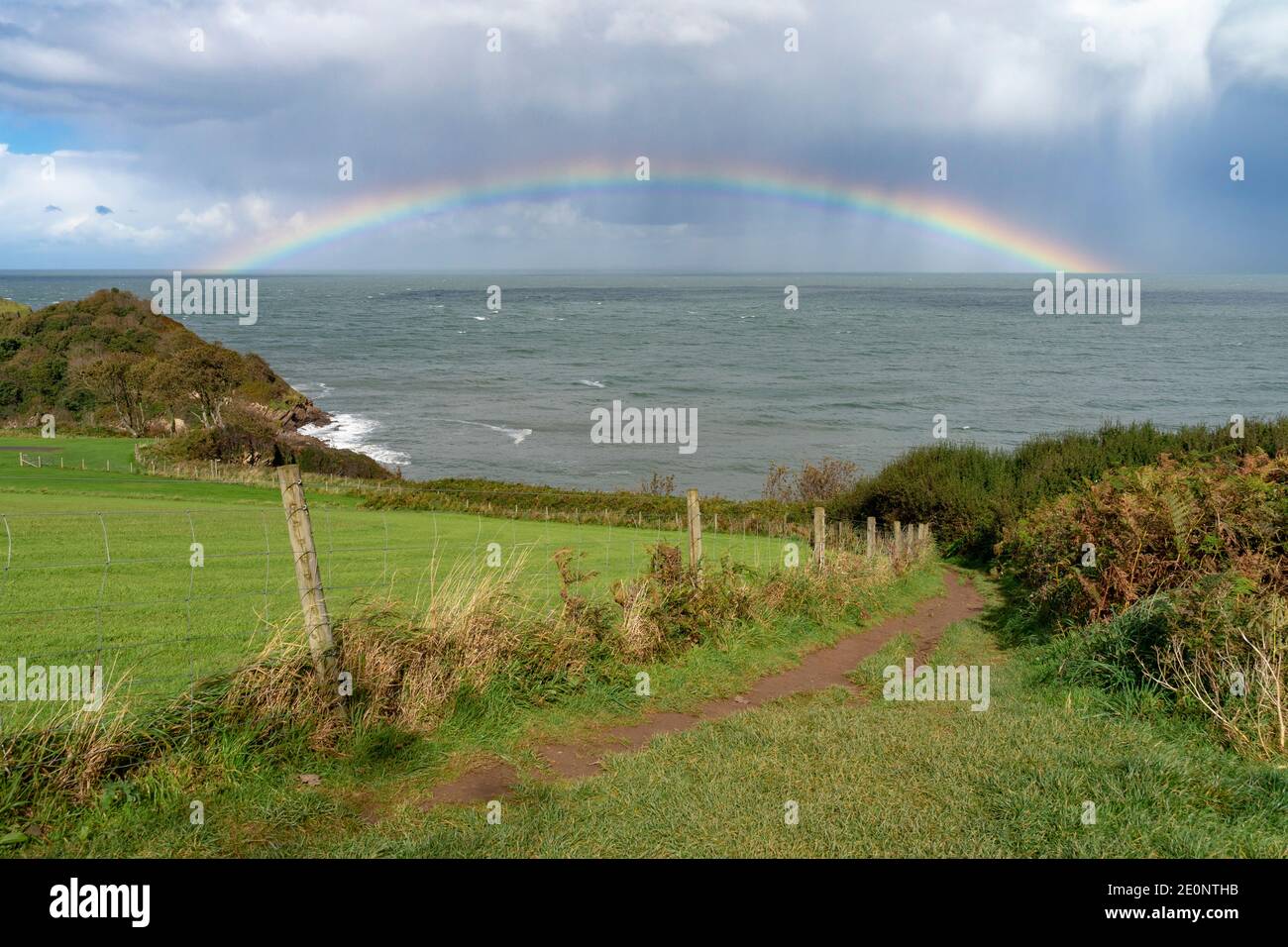 Rainbow out at sea off the Devon coastline - England, UK Stock Photo