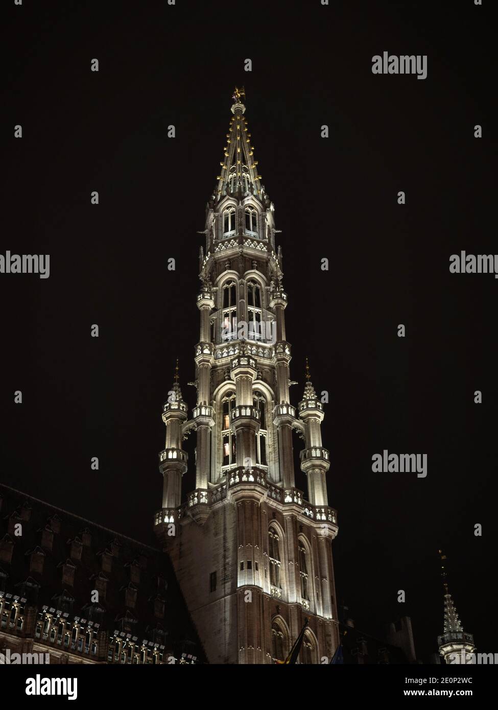 Illuminated spire tower of Brussels City Town Hall Stadhuis medieval gothic architecture at grand place grote markt square in night sky Bruxelles Belg Stock Photo