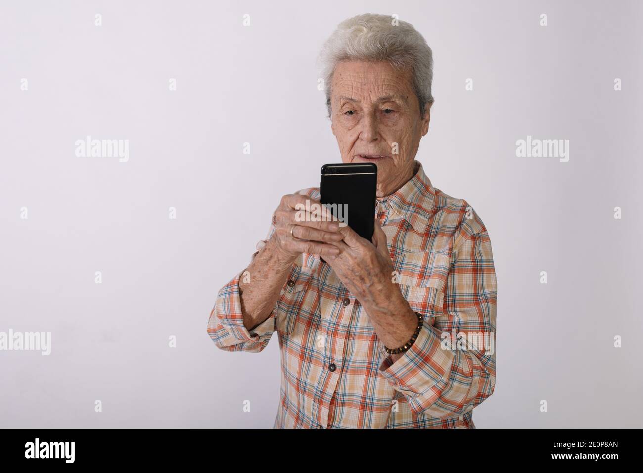 Elderly woman looking at her smartphone screen in amazement. Stock Photo