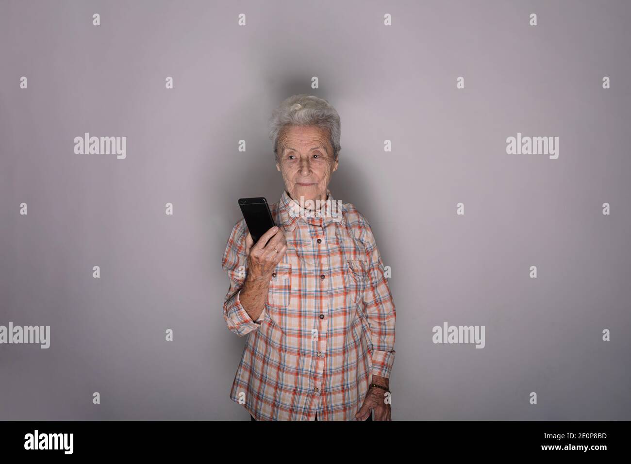 Old woman looking at a smartphone. Stock Photo