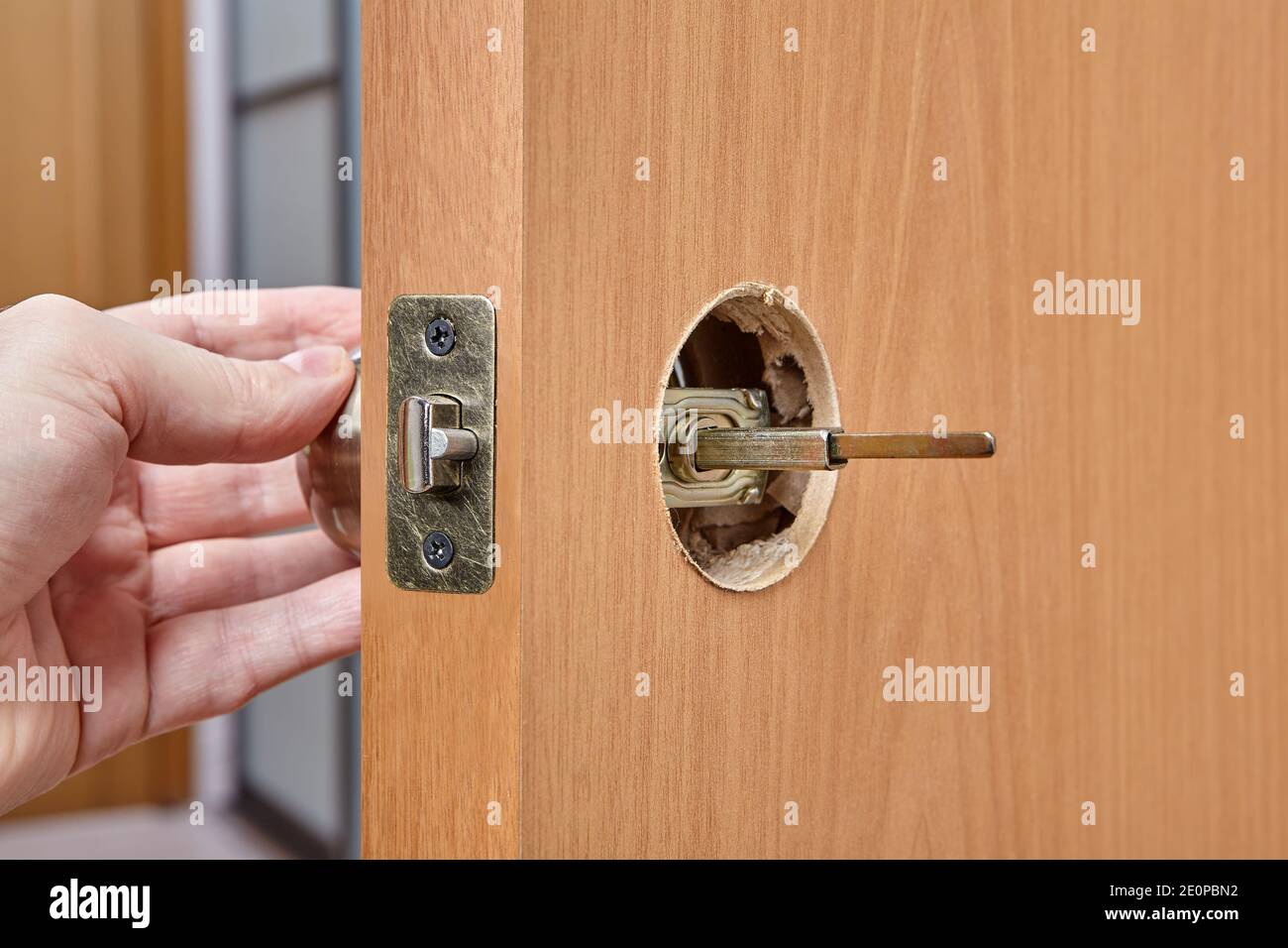 The installer pushes the spindle of door handle through the hole in the latch assembly and face bore. Stock Photo