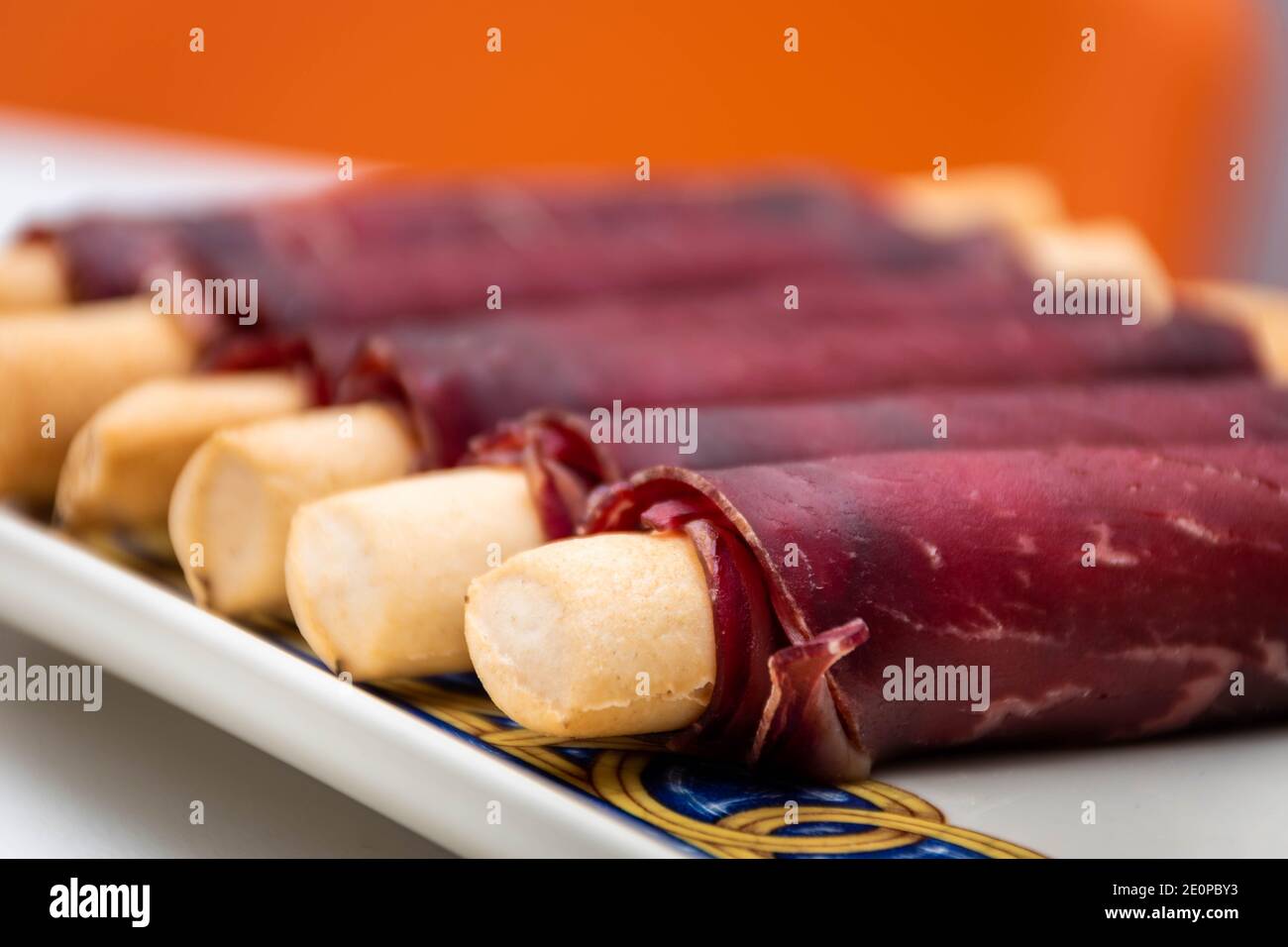Cecina de León and ham rolled up into an elongated snack. Macro view with background blur Stock Photo